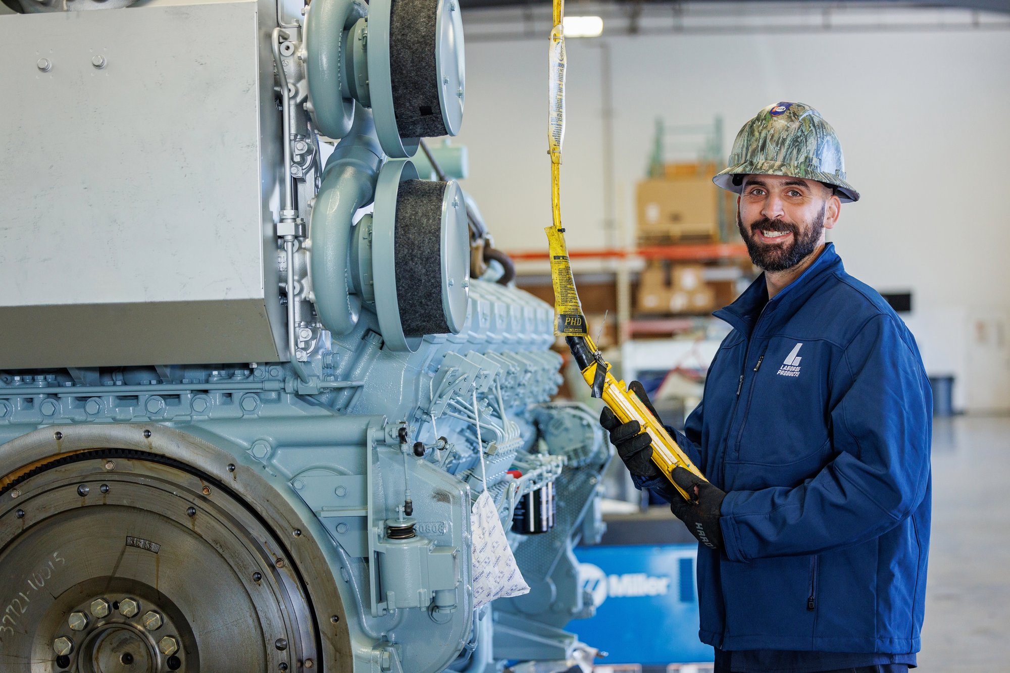 Laborde Products technician standing beside a Mitsubishi marine engine during service, supporting long-term reliability through proper marine diesel engine maintenance practices.
