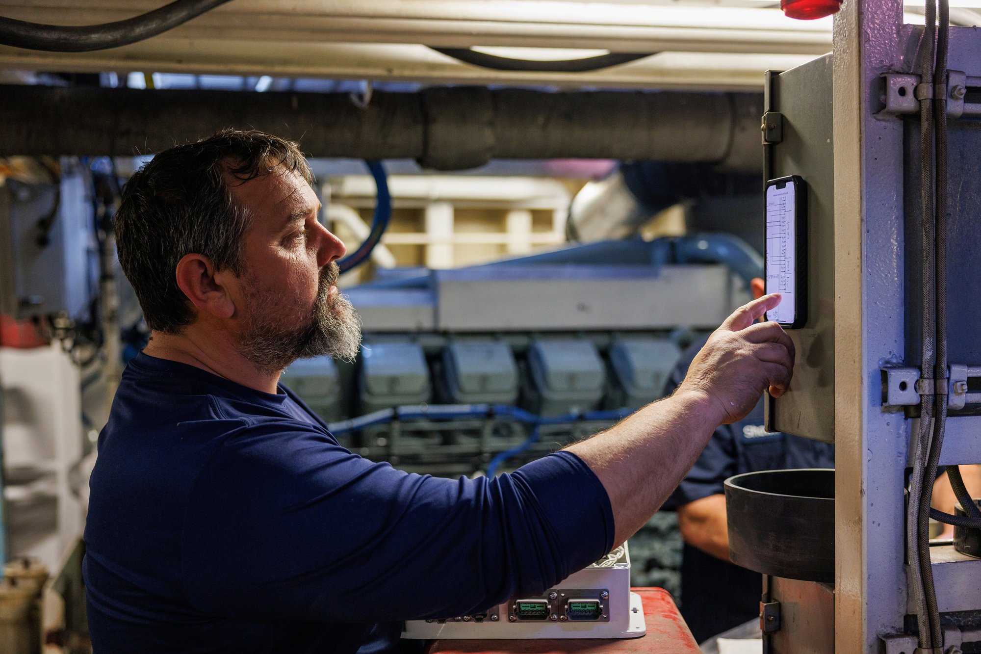 Laborde marine service technician performing diesel engine diagnostics on a vessel using an onboard control system.