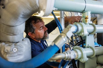 Laborde marine diesel technician troubleshooting fuel and mechanical systems inside a vessel engine room.