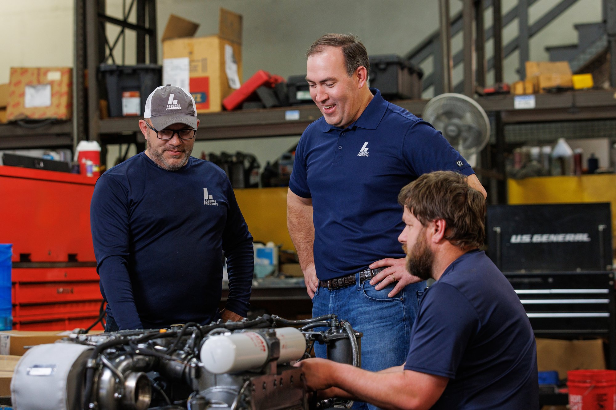 Laborde Products team members collaborating during a marine diesel engine inspection, focusing on service practices that extend engine longevity and reliability.
