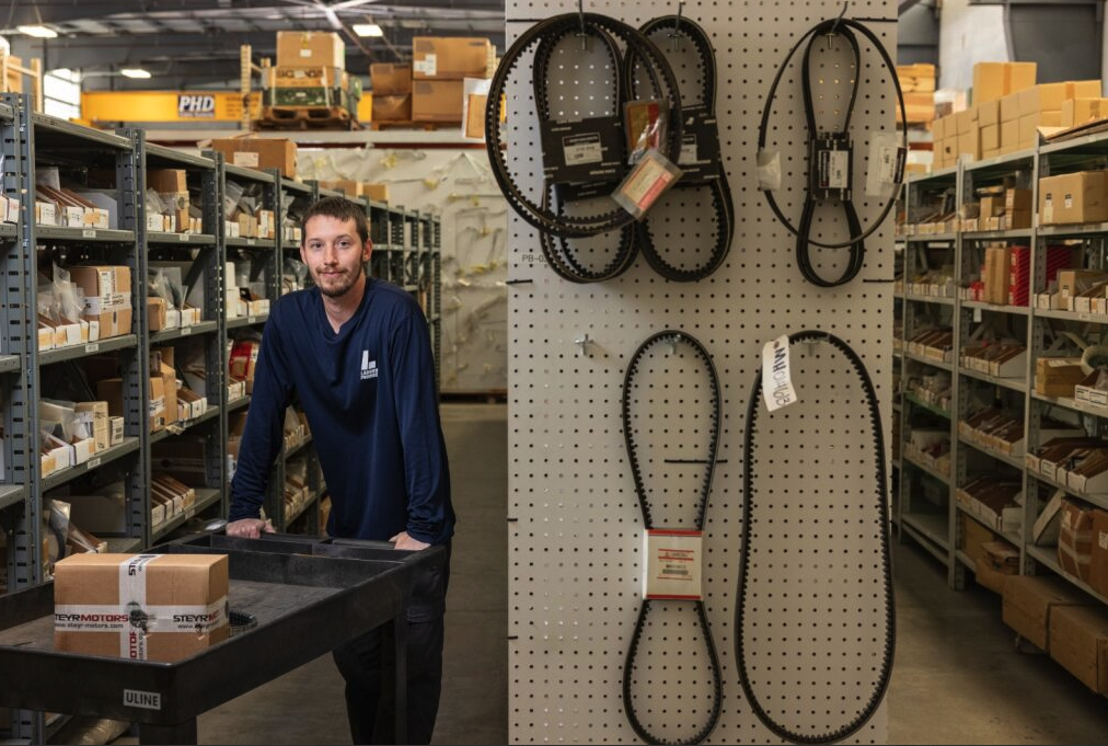 Marine diesel engine parts warehouse with technician preparing OEM engine belts and components for commercial vessels